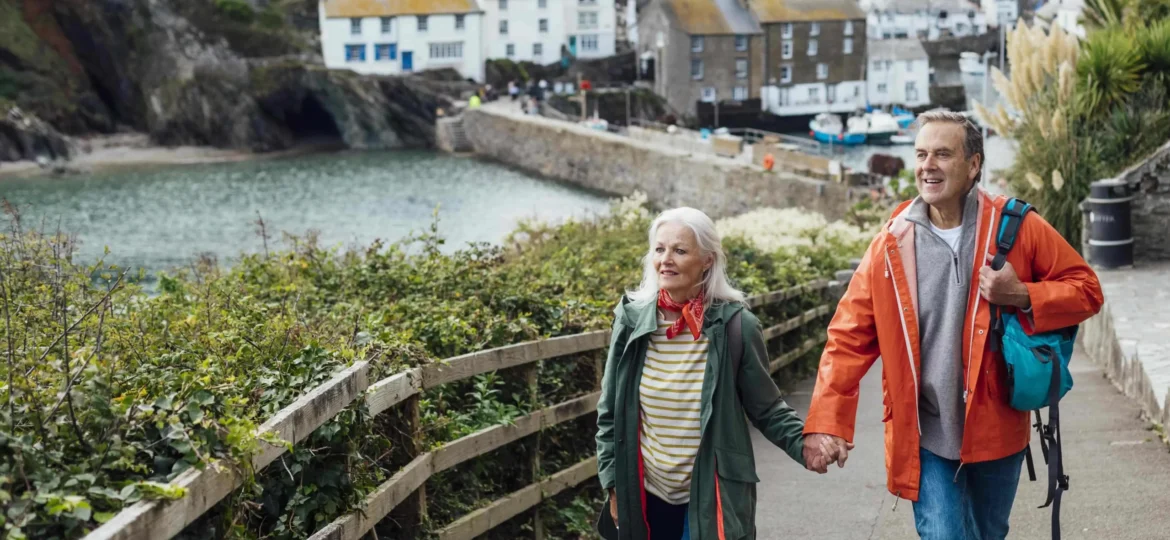 Senior-couple-walking-in-a-village-in-Cornwall-e1654766446581.jpg